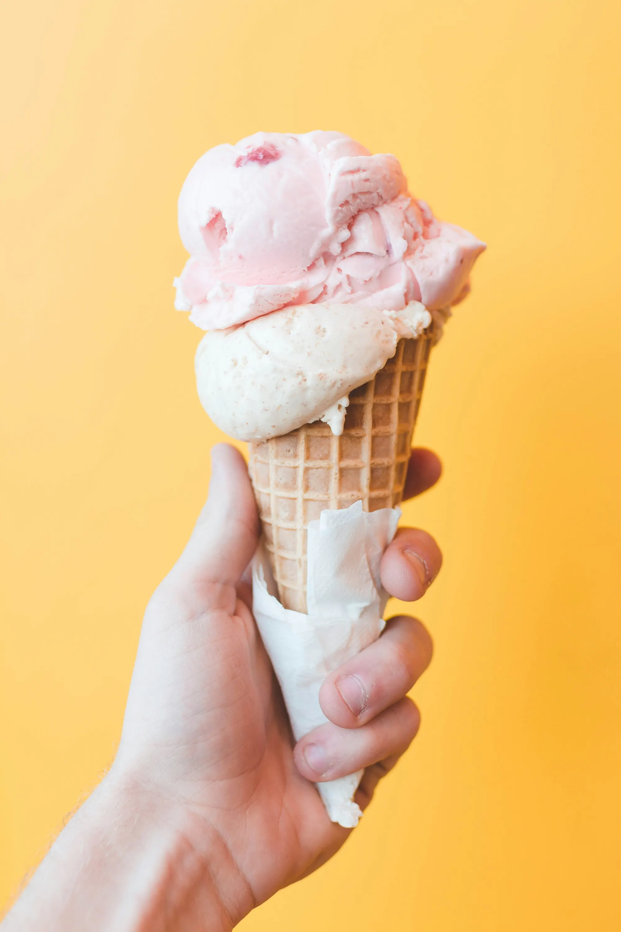 a hand holding a cone of ice cream